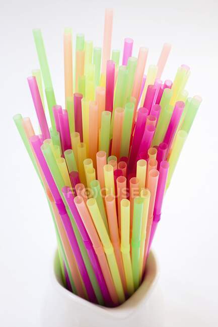 Colourful neon straws in a pitcher — Stock Photo