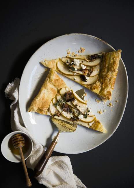 Two slices of puff pastry with pears, goat's cheese and honey (top view) — Stock Photo