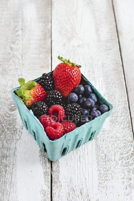 Различные свежие ягоды в картонной коробке — стоковое фото