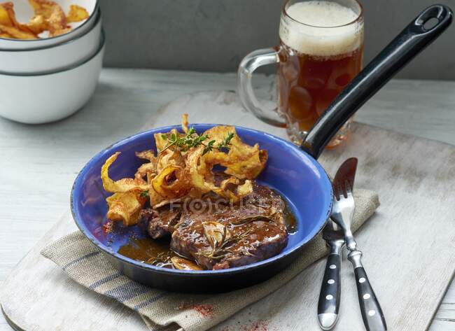 Entrecote with potato crumbs and glass of dark beer — Stock Photo