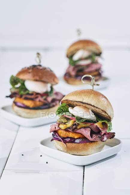 Mini brioche burges with pastrami, vegetables and poached quail's eggs — Stock Photo