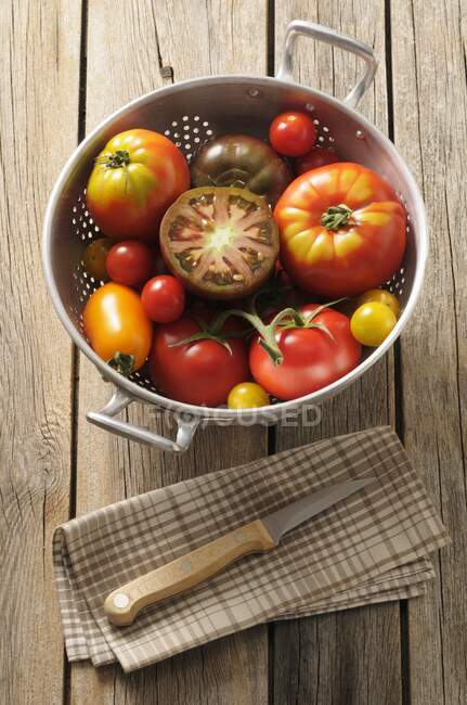 Vários tipos de tomates em um escorredor — Fotografia de Stock