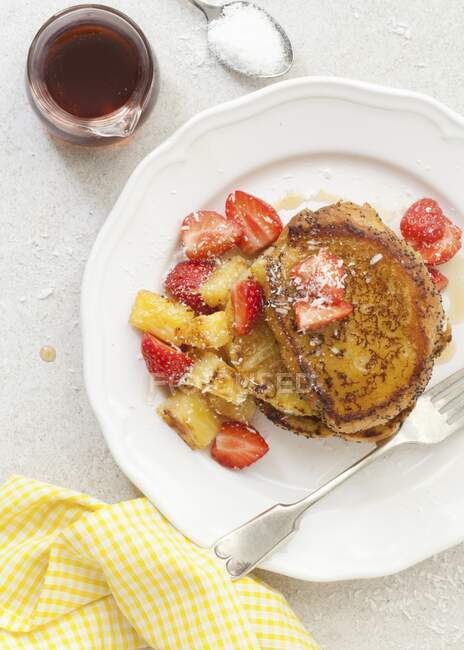 Vegan French toast with griddled pineapple, strawberries, coconut flakes and maple syrup — Stock Photo