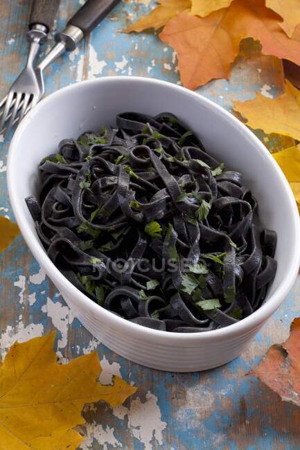 Black noodles with oil and parsley — Stock Photo