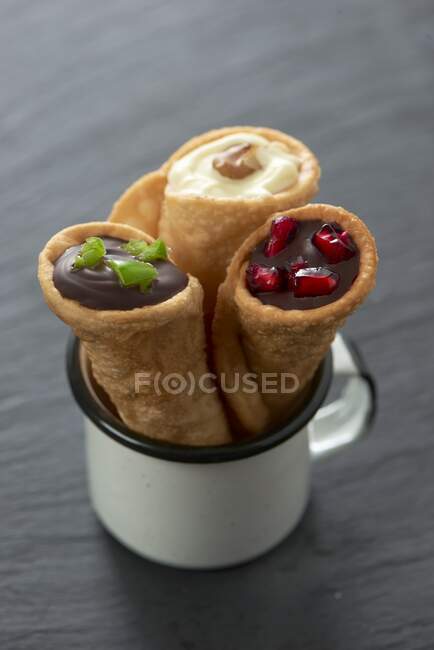 Filled tortilla cones with chilli chocolate, white chocolate with walnut and dark chocolate with pomegranate seeds (Mexico) — Stock Photo