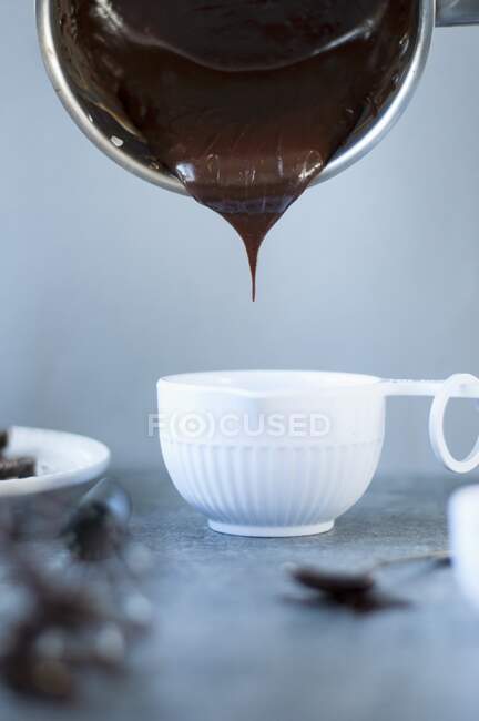 Crème au chocolat noir verser dans un petit bol — Photo de stock