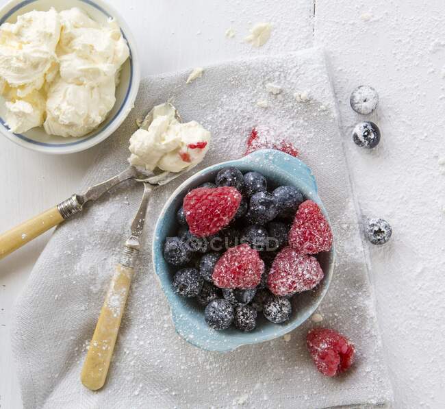 Raspberries Blueberries in a pot with whipped cream — Stock Photo
