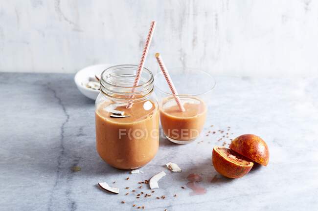 Blood orange smoothie with apple, coconut cream and linseed — Stock Photo