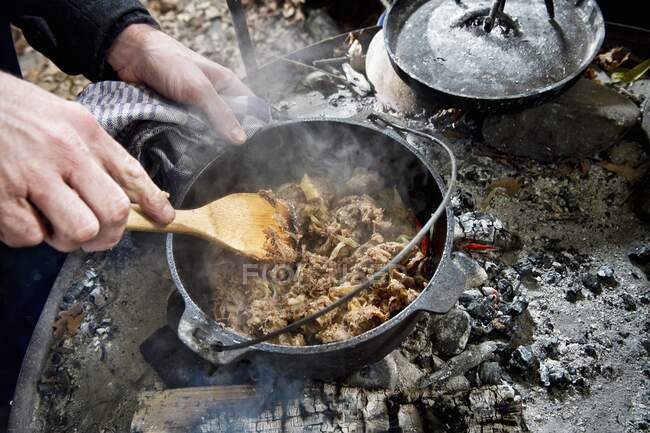 How to make a meat dish in a Dutch oven over a fire place — Stock Photo