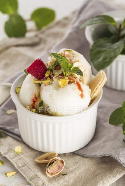 Vanilla ice cream with raspberries, mint, nuts and jam — Stock Photo