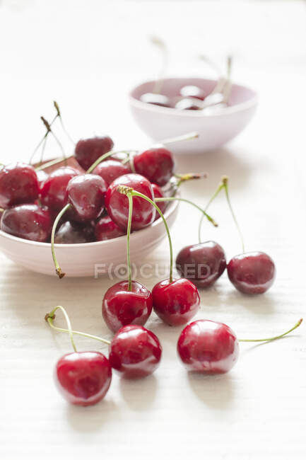Cerejas frescas em uma tigela em um fundo branco — Fotografia de Stock