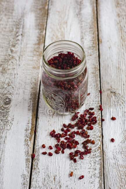 Dried goji berries in a glass jar on a wooden background — Stock Photo