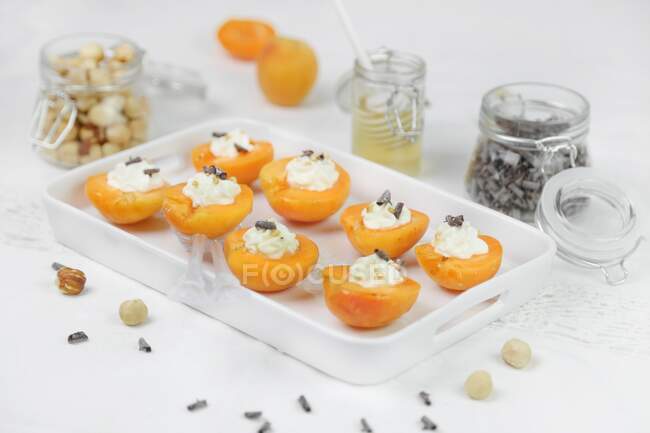Albaricoques con queso crema miel y chocolate - foto de stock