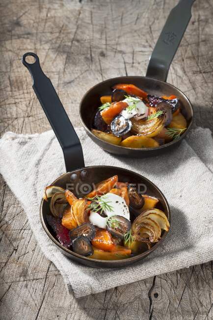 Stewed root vegetables with sour cream and dill — Stock Photo