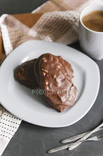 Chocolate-covered nut biscuits served with a cup of coffee — Stock Photo