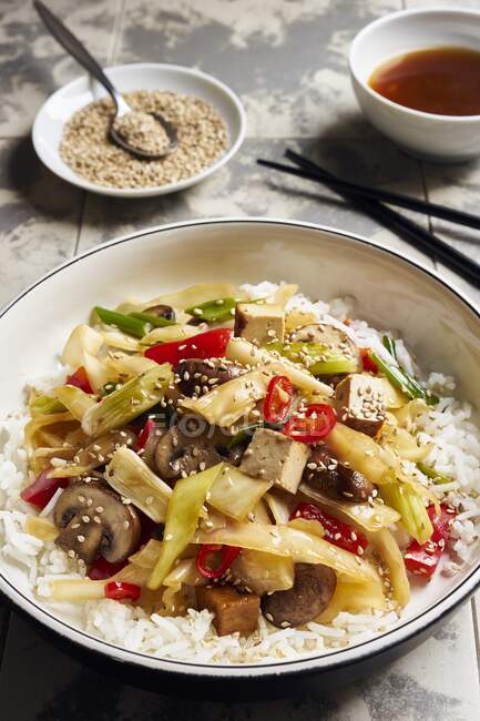 Asian style white cabbage with tofu, chili, peppers, mushrooms and sesame seeds on rice — Stock Photo
