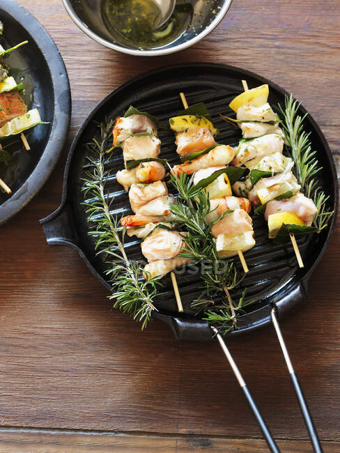 Fish skewers with rosemary in grill pan — Stock Photo