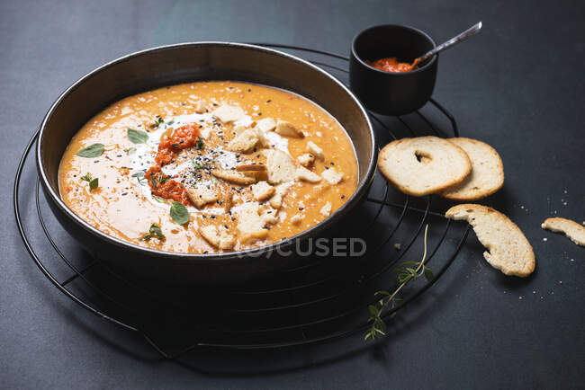 Sopa vegana de pimiento y patata con ajvar y chips de pan de ajo - foto de stock