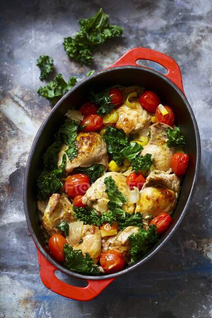 Chicken with tomato and kale in casserole dish — Stock Photo