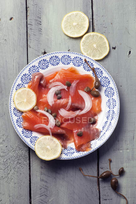Smoked salmon with capers, onions and lemon — Stock Photo
