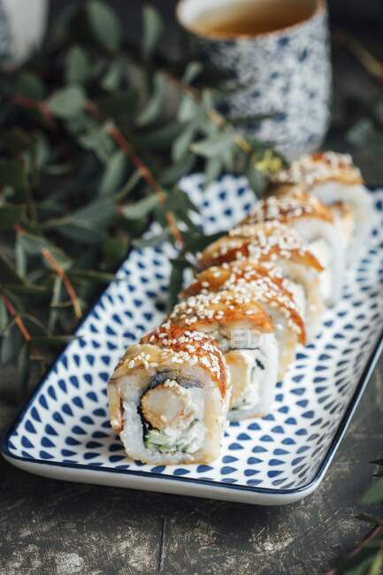 Rouleaux de sushi à l'anguille, crevettes tempura, fromage frais et concombres — Photo de stock