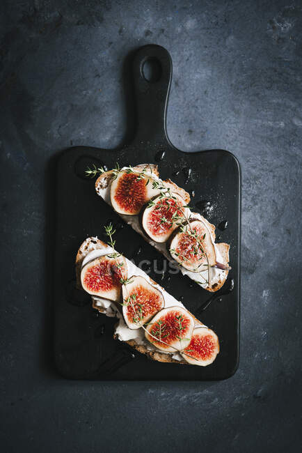 Figs and goat's cheese sandwich of bread slices on board — Stock Photo