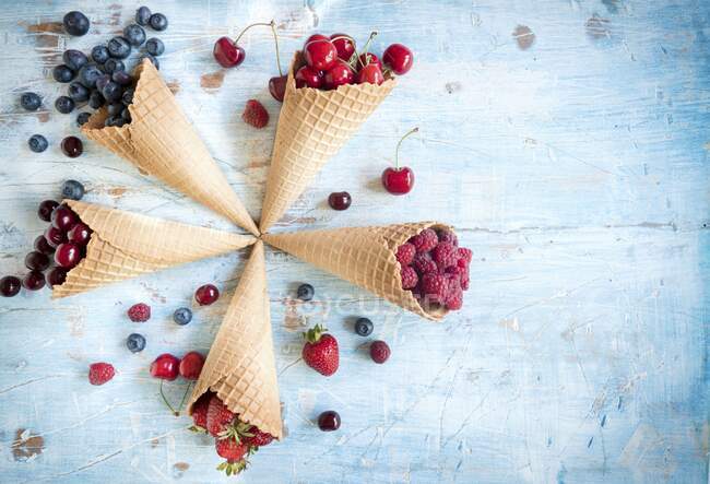 Várias bagas e cerejas em cones de sorvete — Fotografia de Stock
