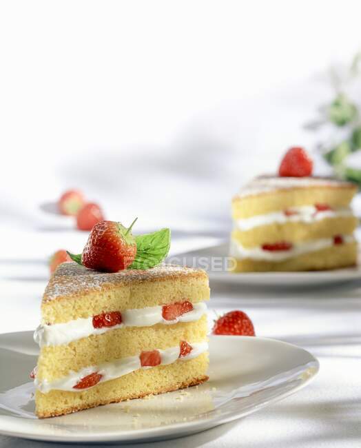 Deux morceaux de gâteau aux fraises à la crème fouettée — Photo de stock