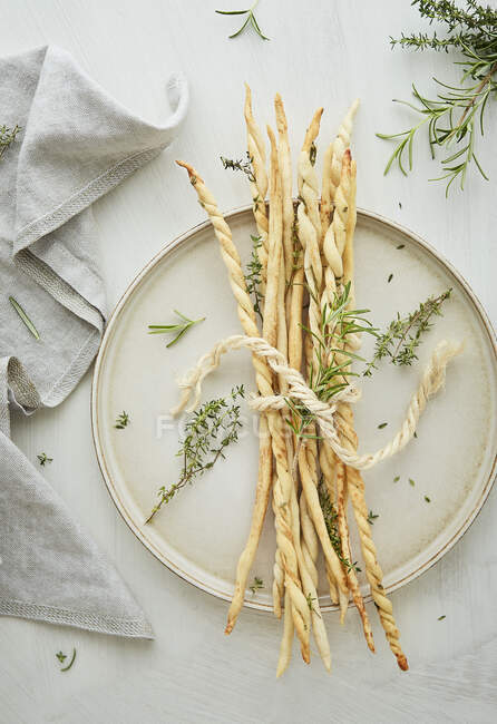 Grissini with rosemary and thyme on a light background — Stock Photo