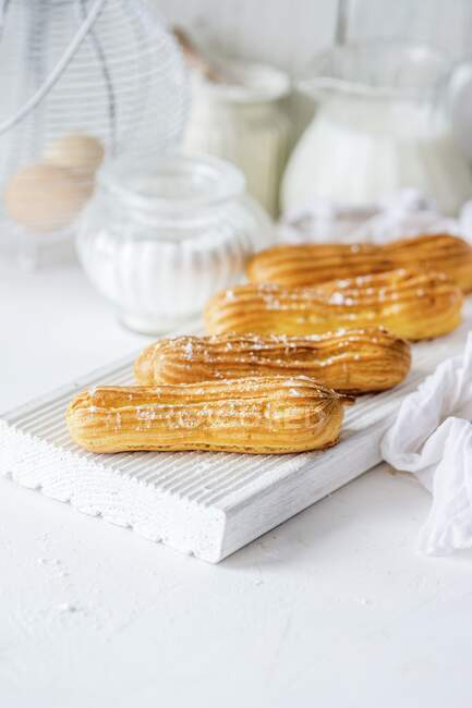 Homemade eclairs on white board — Stock Photo