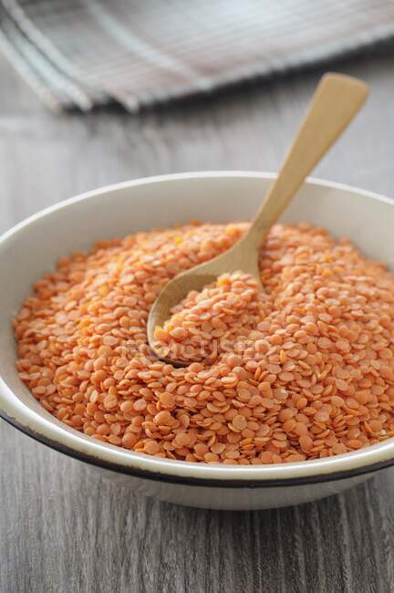Red lentils with a spoon in a bowl — Stock Photo