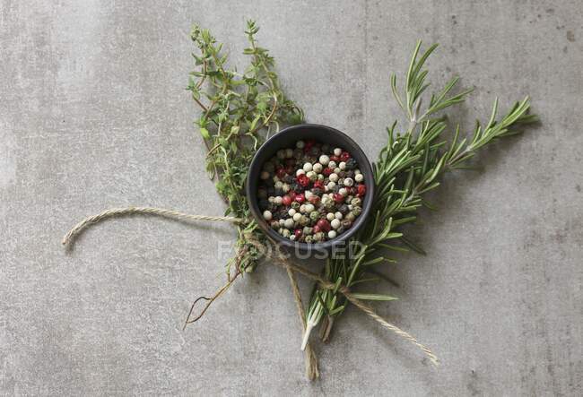Peppercorns and fresh herbs — Stock Photo