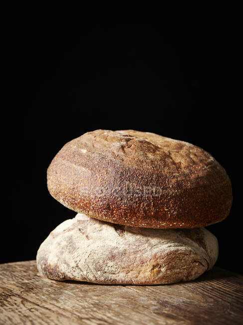 Dos panes de masa fermentada sobre mesa de madera - foto de stock
