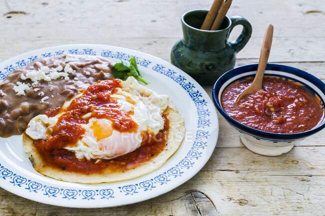 Huevos Rancheros (fried eggs on a corn tortilla with roasted beans and tomato sauce, Mexico) — Stock Photo