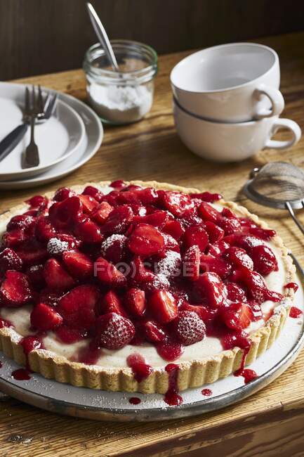 Strawberry tart with vanilla cream on a rustic wooden table — Stock Photo