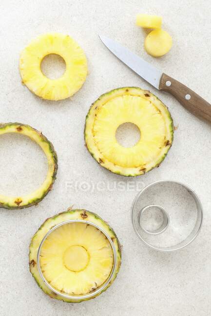 Fresh pineapple rings being cut out — Stock Photo