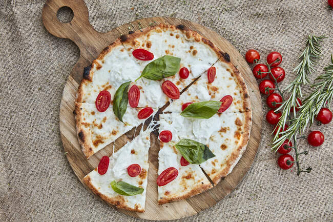 A pizza with buffalo mozzarella, cherry tomatoes and basil — Stock Photo