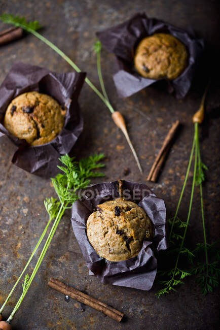 Chocolate muffins with raisins and spices on a dark wooden background. selective focus. — Stock Photo