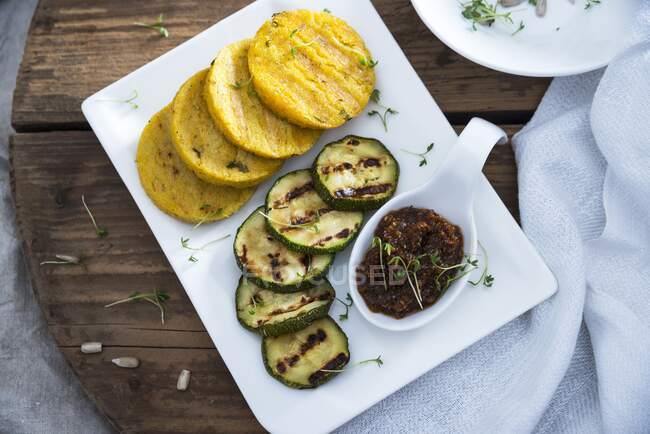 Grilled polenta and courgette slices with sunflower seed and tomato pesto (vegan) — Stock Photo