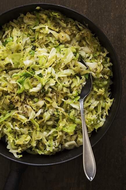 Fried spring cabbage in a cast iron pan — Stock Photo