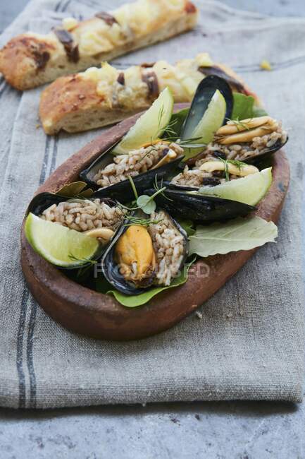 Mussels with rice and lime wedges — Stock Photo