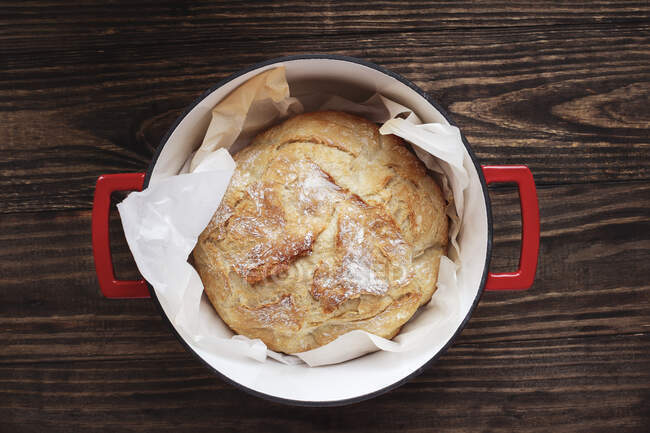 Hausgemachtes rundes Artisan-Brot, frisch gebacken im holländischen Emaille-Gusseisen-Ofen. — Stockfoto