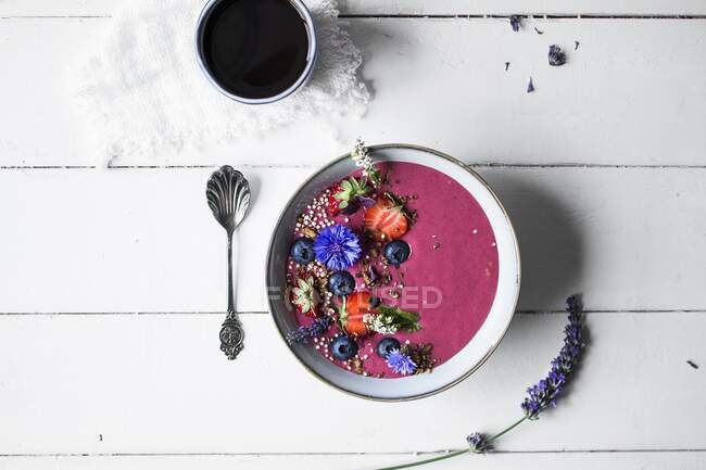 Uma tigela de smoothie com frutas, flores comestíveis e muesli sem glúten — Fotografia de Stock