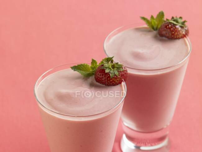 Клубничный йогуртовый коктейль со свежими ягодами в стаканах — стоковое фото