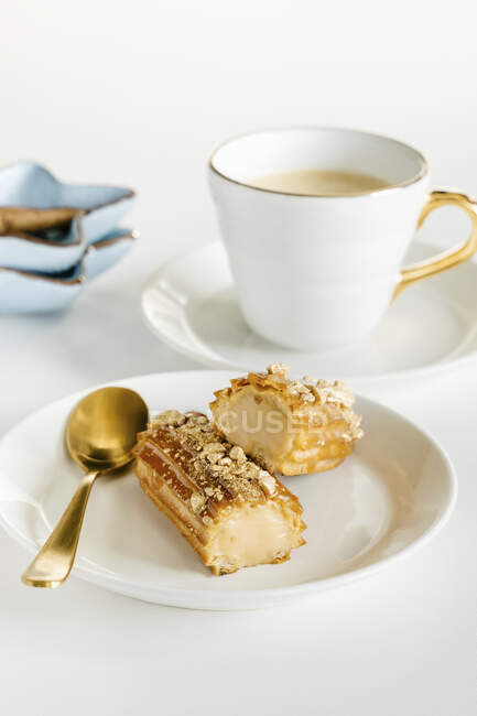 Salted caramel French eclair and coffee — Stock Photo