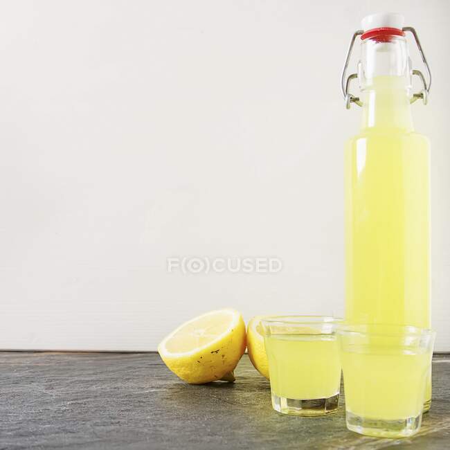 Limoncello en bouteille et verres — Photo de stock
