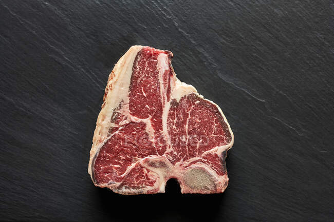 A t-bone steal on a black surface — Stock Photo