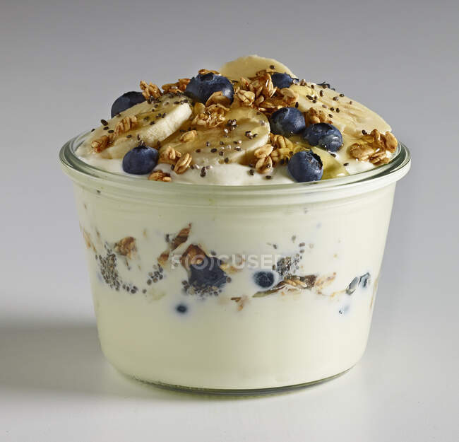 Griechischer Joghurt mit Blaubeeren, Bananen, Honig und Müsli — Stockfoto