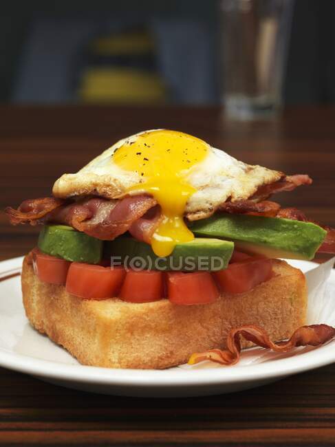 Um ovo frito, abacate e bacon na torrada para brunch — Fotografia de Stock