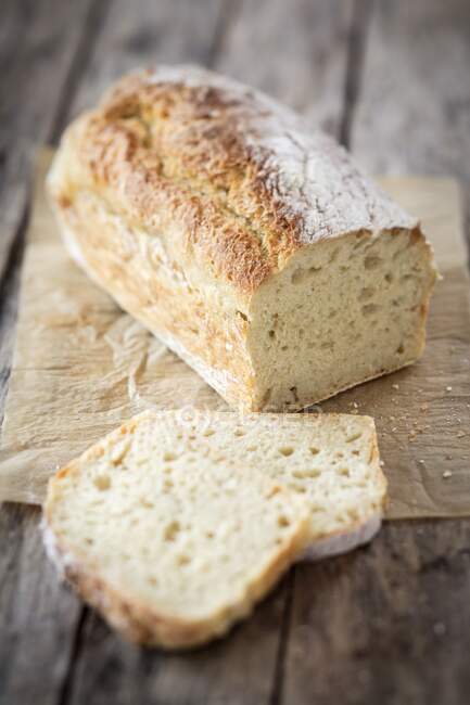 Crusty white bread with dried yeast on wooden board — Stock Photo